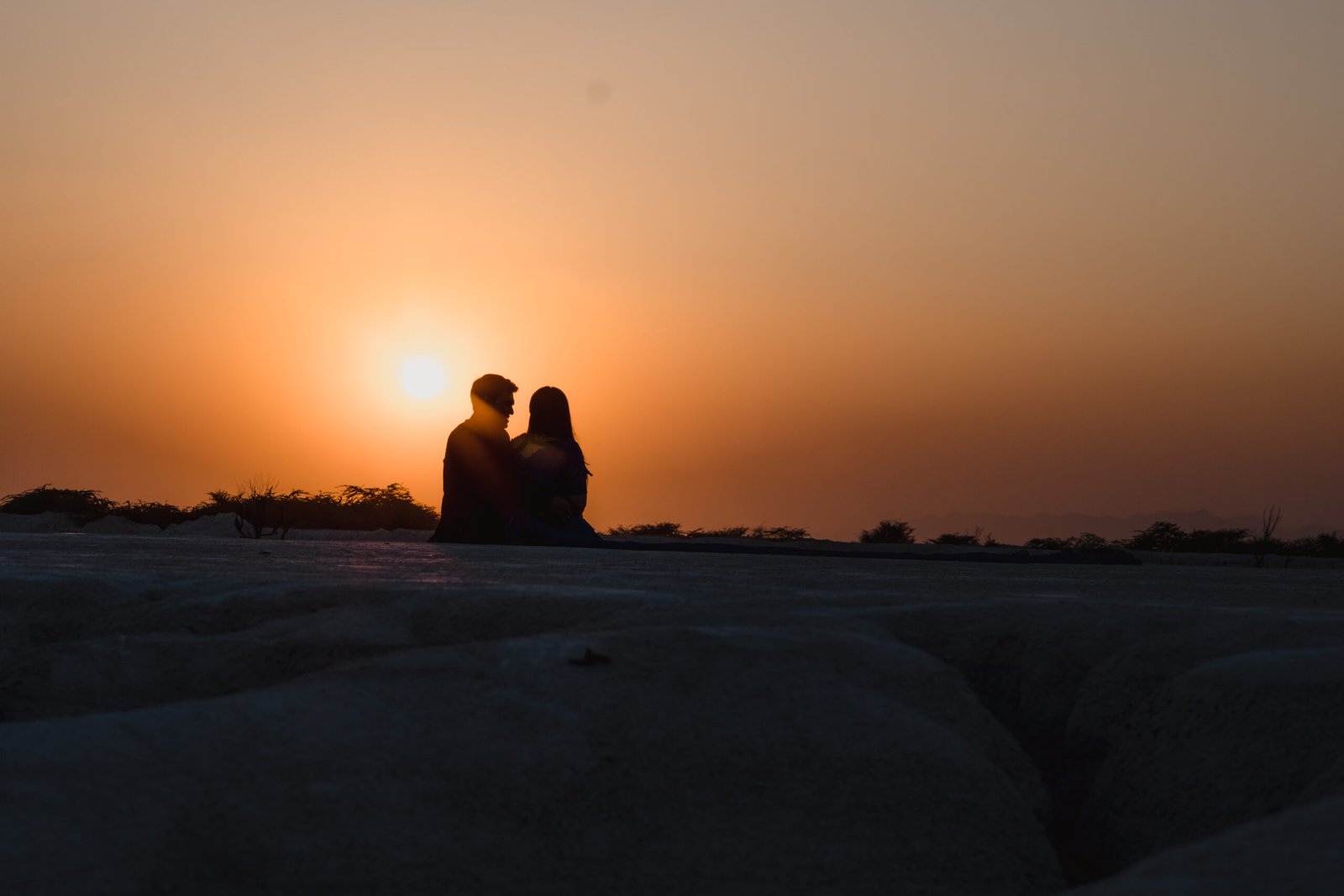 A couple silhouetted against the golden sunset