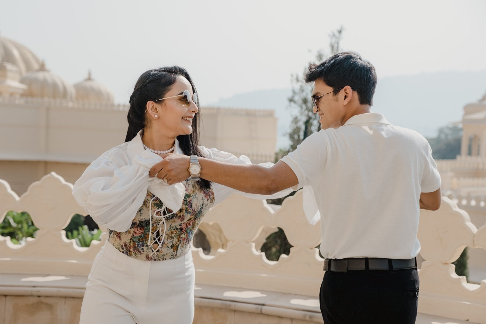 A playful couple moment on a sunlit palace terrace