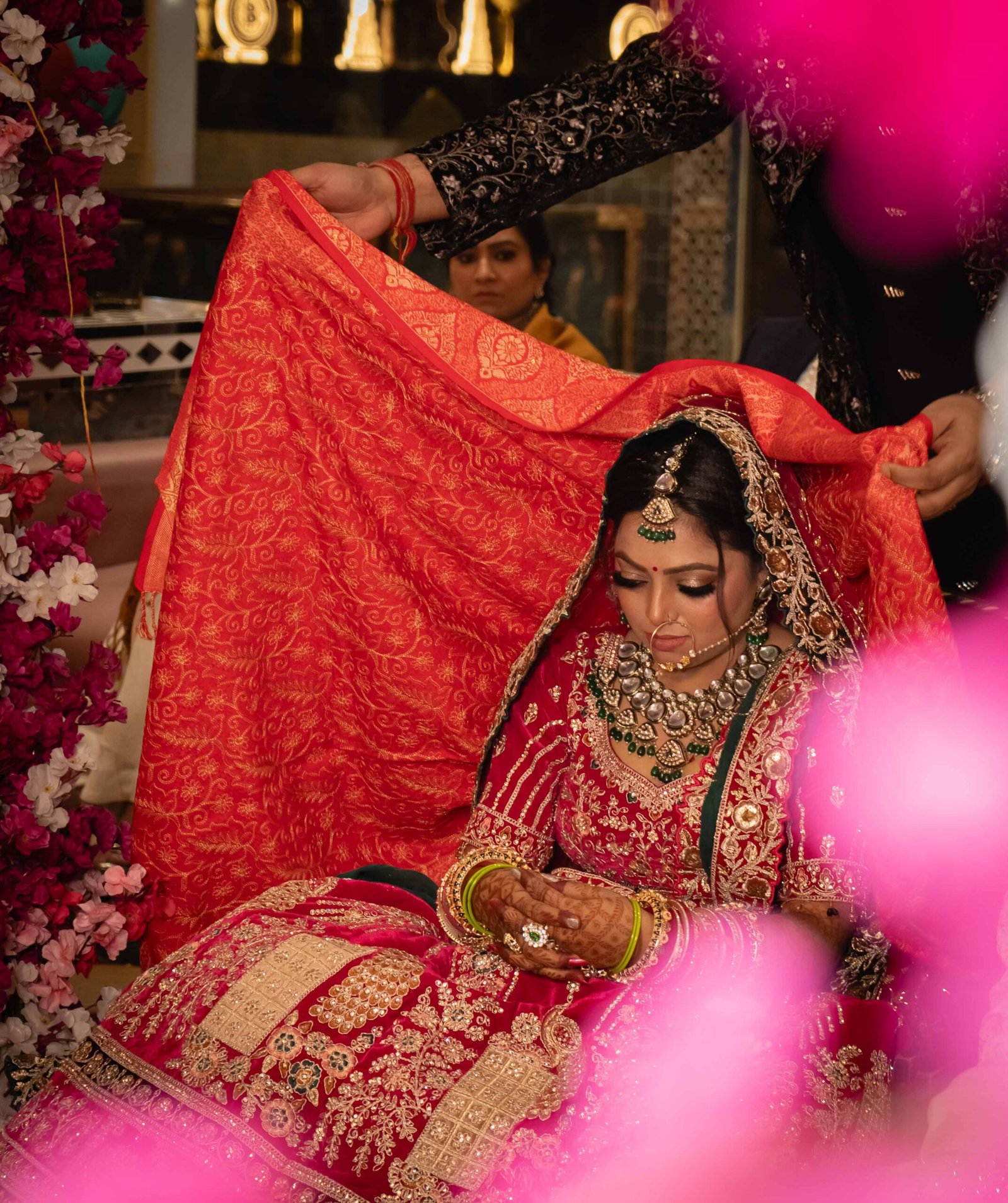 A bride beneath her red wedding veil